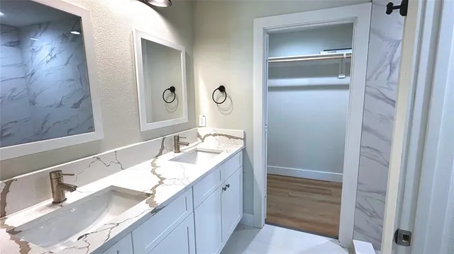 a bathroom with a granite countertop sink and a mirror