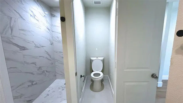 a bathroom with a granite countertop shower and mirror