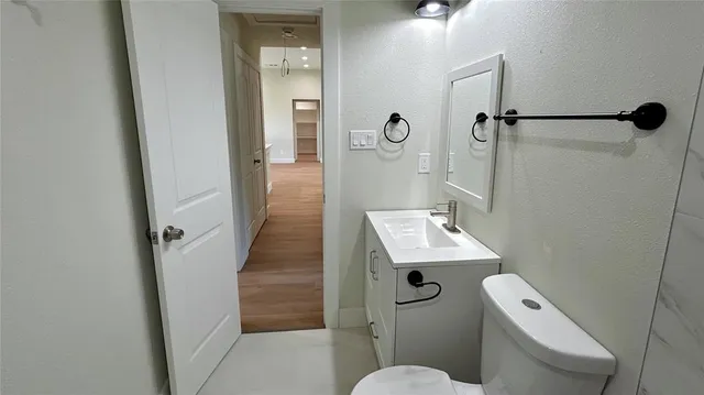 a bathroom with a sink a toilet a mirror and shower