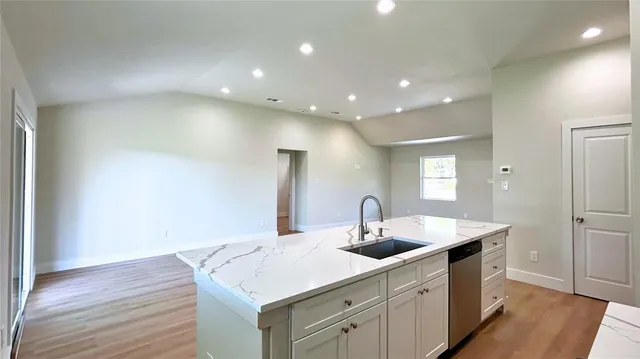 a kitchen with a sink and wooden floor