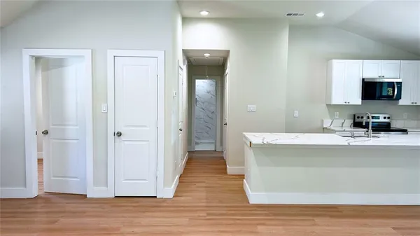 a view of a living room with hardwood floor and a bathroom