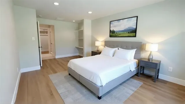 a spacious bedroom with a bed and a painting on the wall