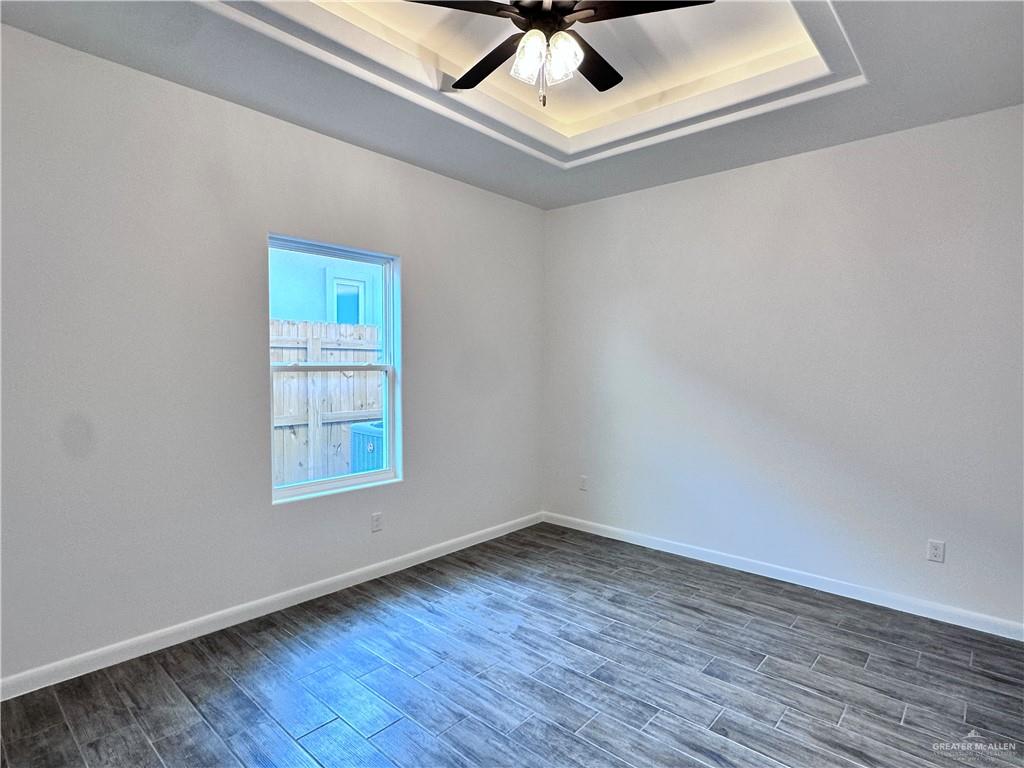 1100 Azalea Street Mission, TX 78573 - Photo 20 of 24 an empty room with wooden floor and windows