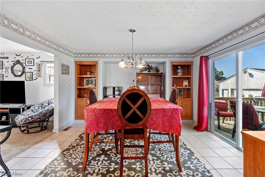 869 Reed Avenue Akron, OH 44306 - Photo 9 of 25 Carpeted dining room featuring a textured ceiling, an inviting chandelier, and built in shelves