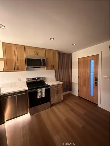 a kitchen with stainless steel appliances granite countertop a stove a sink and a microwave