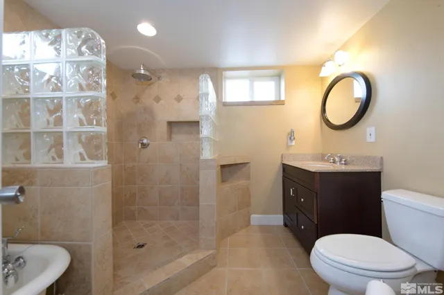 a bathroom with a sink a toilet and shower