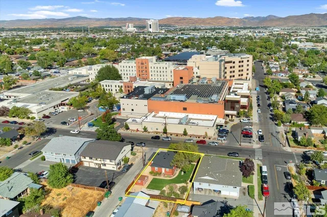 an aerial view of a city with lots of residential buildings and ocean view in back