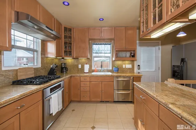 a kitchen with stainless steel appliances granite countertop a stove sink and cabinets