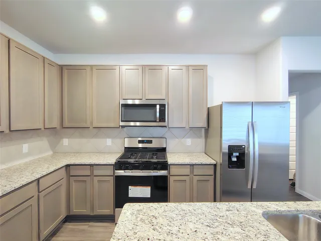 a kitchen with a refrigerator stove and sink