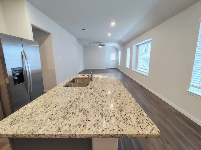 a view of kitchen island wooden floor and refrigerator