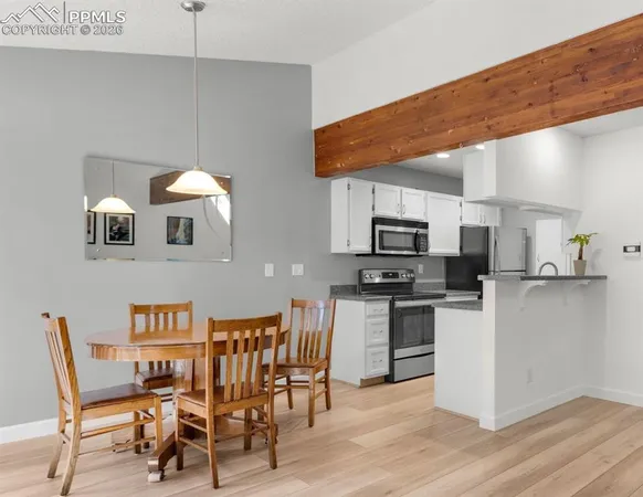 a open kitchen with stainless steel appliances kitchen island granite countertop a table chairs microwave and sink
