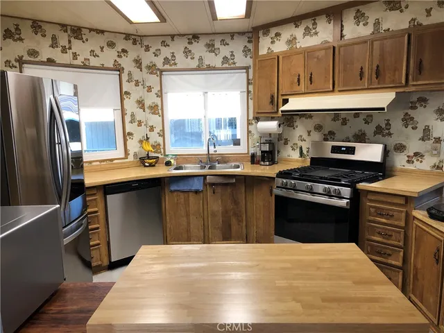 a kitchen with granite countertop a sink stove and refrigerator