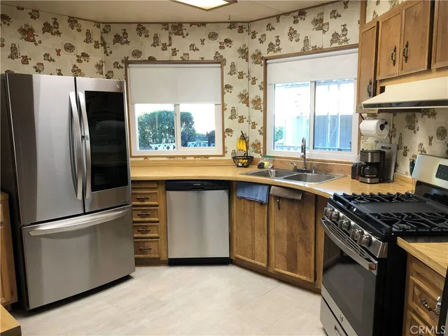 a kitchen with stainless steel appliances granite countertop a stove a sink and a refrigerator