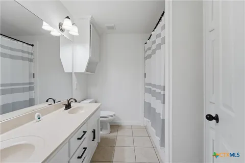 a bathroom with a double vanity sink mirror and shower