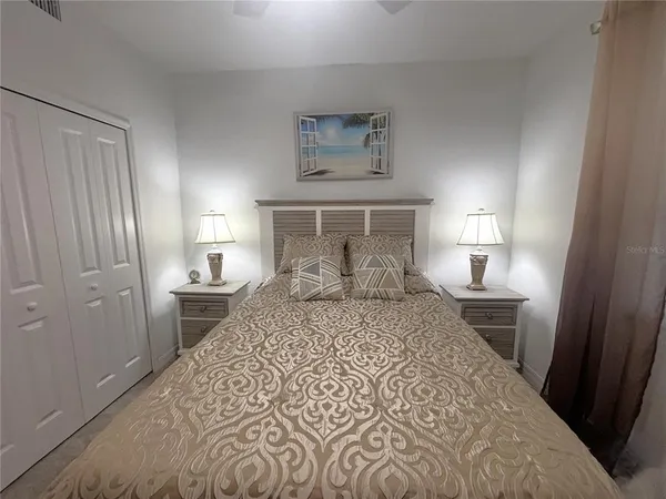 a bedroom with a bed and a lamp on desk