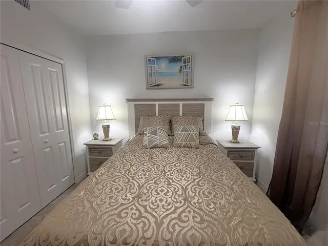 a bedroom with a bed and a lamp on desk