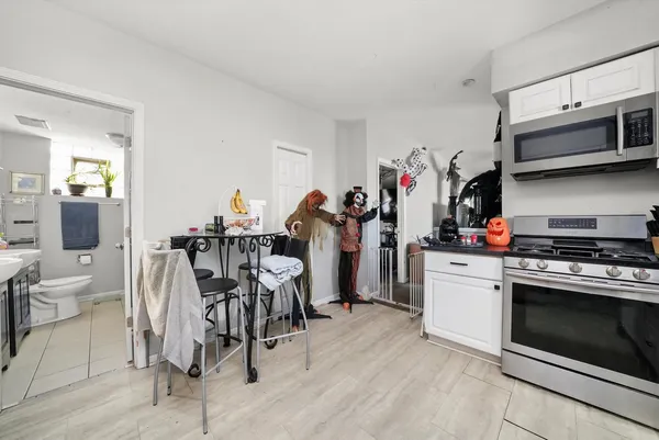 a kitchen with granite countertop a refrigerator oven a sink and cabinets