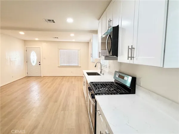 a kitchen with stainless steel appliances a stove sink and microwave