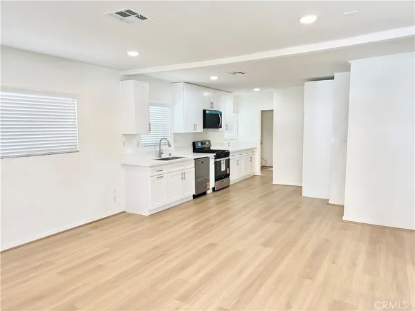 a large kitchen with a lot of counter space and wooden floor