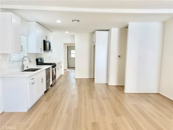 a view of a kitchen with a sink and a refrigerator