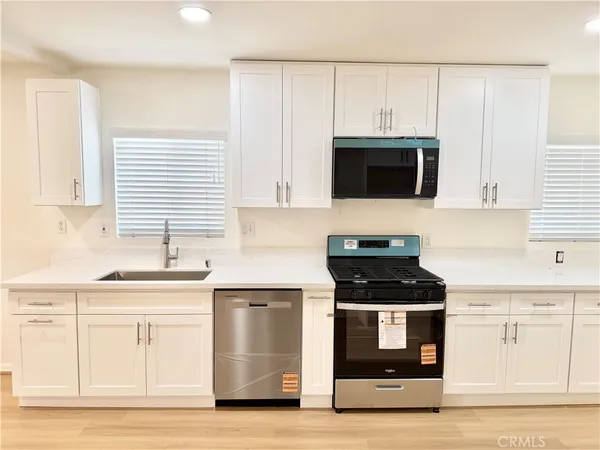 a kitchen with a sink a stove and a refrigerator