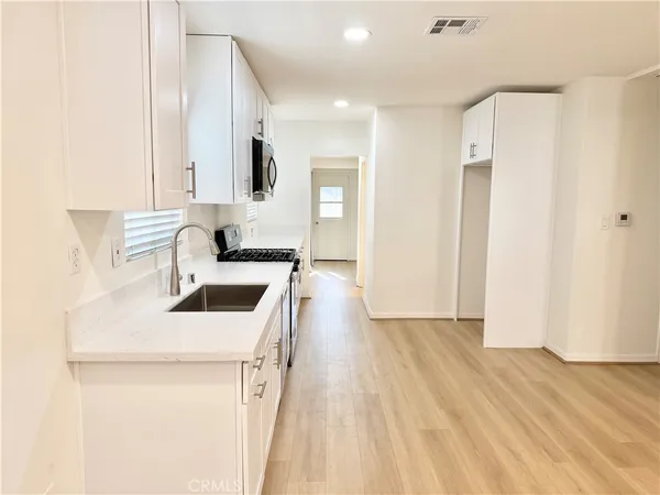 a kitchen with white cabinets stainless steel appliances and sink