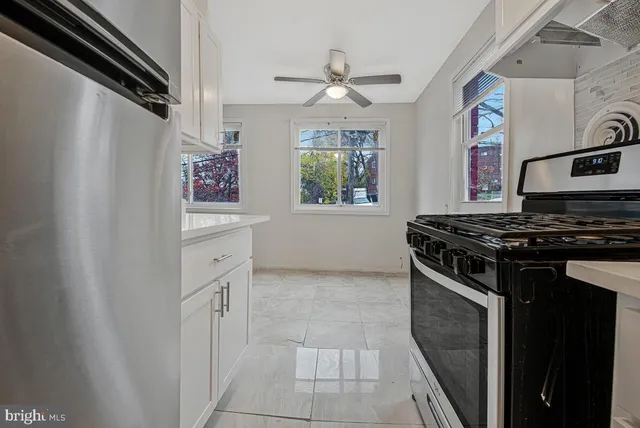 a view of an empty room with wooden floor and window