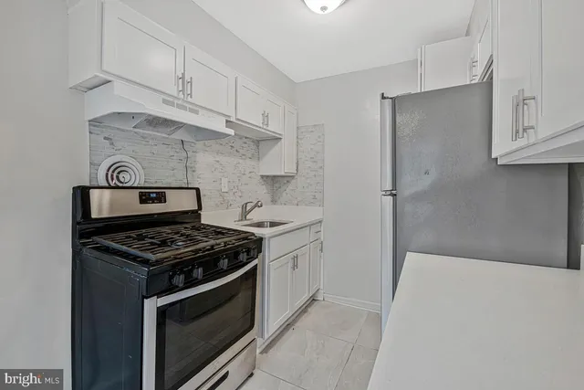 a kitchen with white cabinets and appliances
