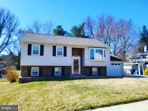 a front view of a house with a yard covered with snow in the background