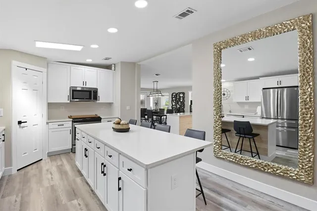 a kitchen with stainless steel appliances kitchen island granite countertop a sink and cabinets