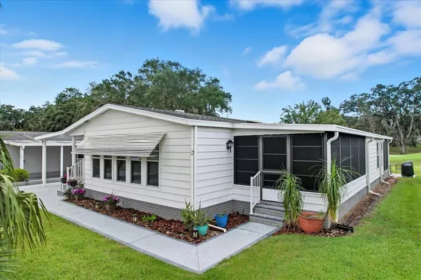 a view of a house with backyard and sitting area