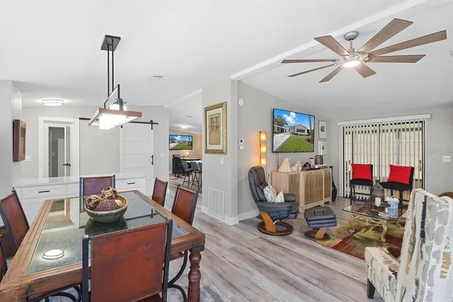 a dining room with furniture a chandelier and wooden floor