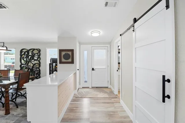 a view of a hallway with white walls and stairs