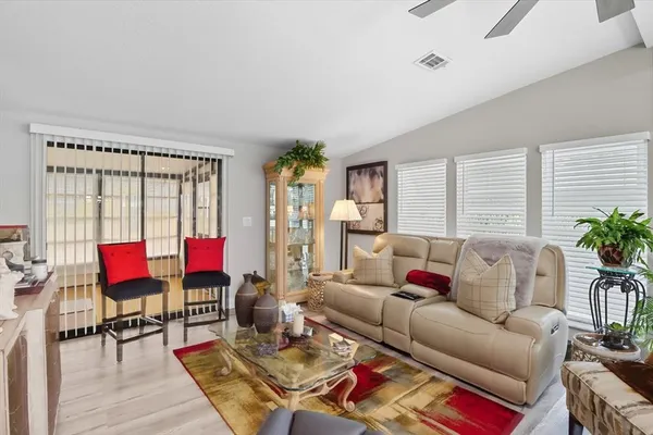 a living room with furniture a rug and a lamp