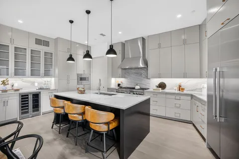 a kitchen with stainless steel appliances granite countertop a sink a stove and a refrigerator