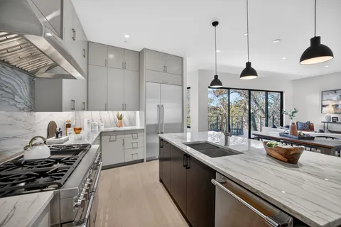 a kitchen with a sink stove and wooden floor