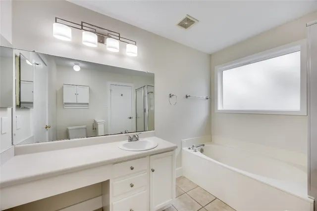a bathroom with a tub a sink and mirror