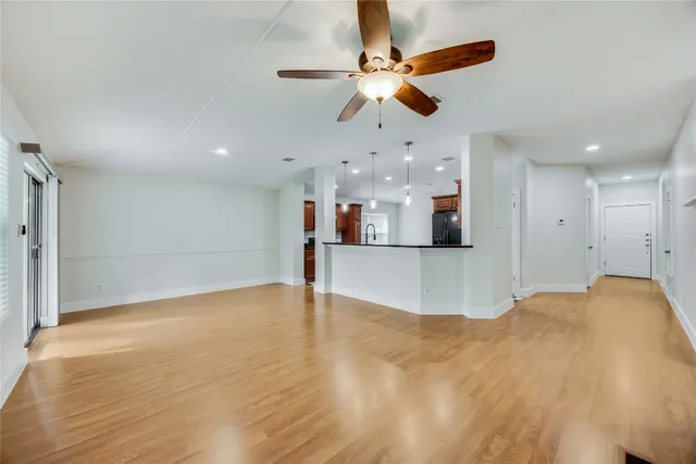 a view of an empty room and kitchen view