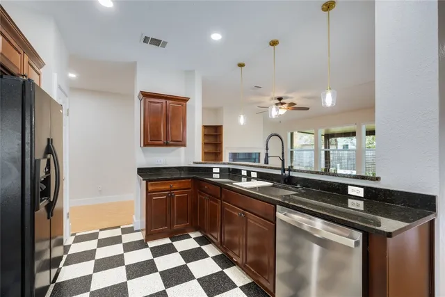 a kitchen with stainless steel appliances granite countertop a sink stove and refrigerator