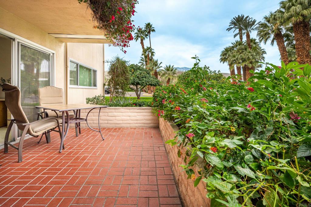 69850 Highway 111, Unit 18 Rancho Mirage, CA 92270 - Photo 3 of 41 a view of a patio with dining table and chairs with potted plants