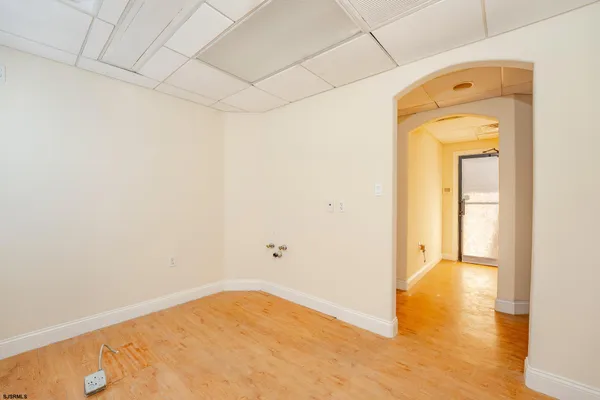a large white kitchen with a sink and a wooden floor
