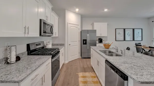 a kitchen with sink refrigerator and stove