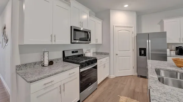 a kitchen with stainless steel appliances granite countertop a sink stove and refrigerator