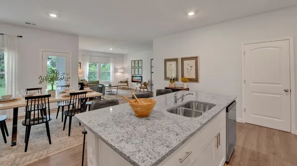 a kitchen with granite countertop a sink a counter top space appliances and cabinets