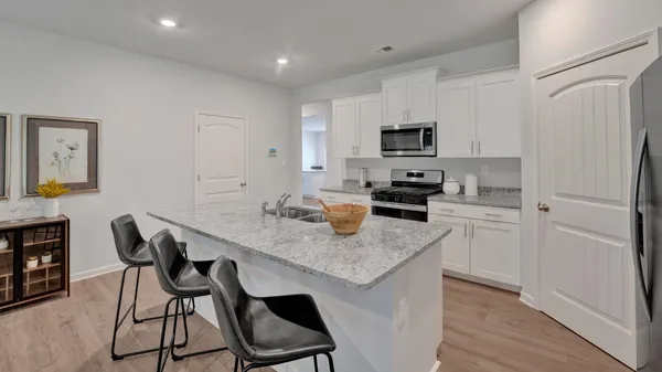 a kitchen with a sink a counter and chairs