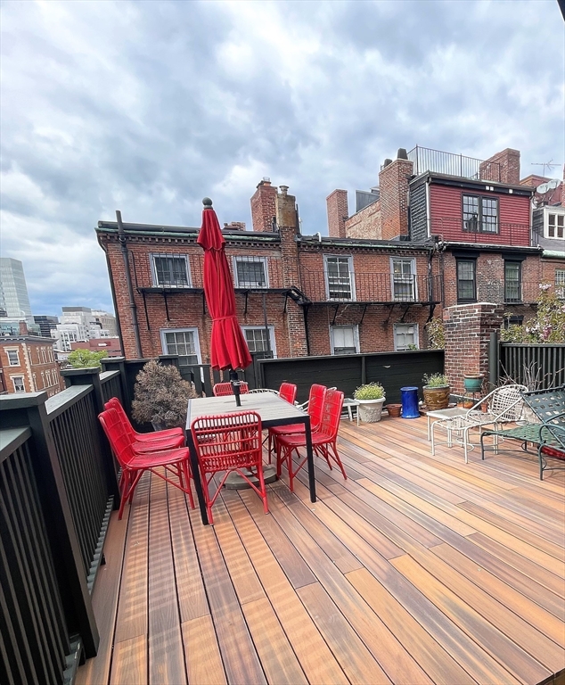 65 Pinckney Street, Unit 3 Boston, MA 02114 - Photo 13 of 14 a view of a rooftop deck with couch and chairs
