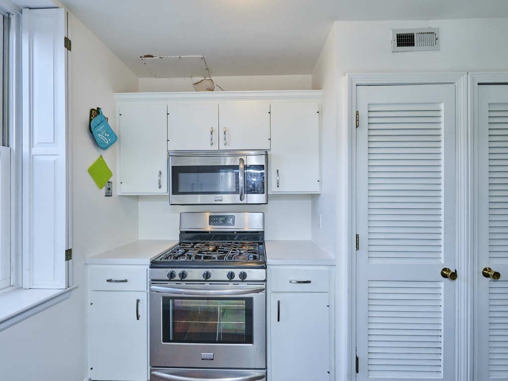 65 Pinckney Street, Unit 3 Boston, MA 02114 - Photo 7 of 14 a kitchen with kitchen island stainless steel appliances a stove refrigerator and cabinets