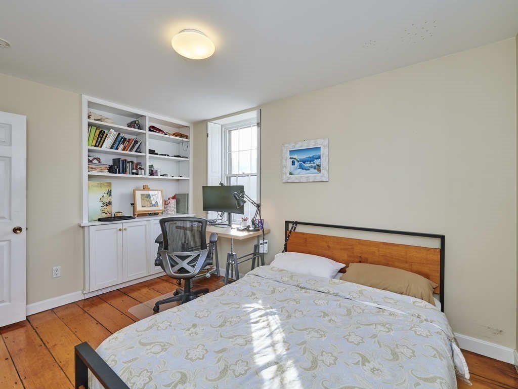 65 Pinckney Street, Unit 3 Boston, MA 02114 - Photo 10 of 14 a bedroom with a bed and a bookshelf in it