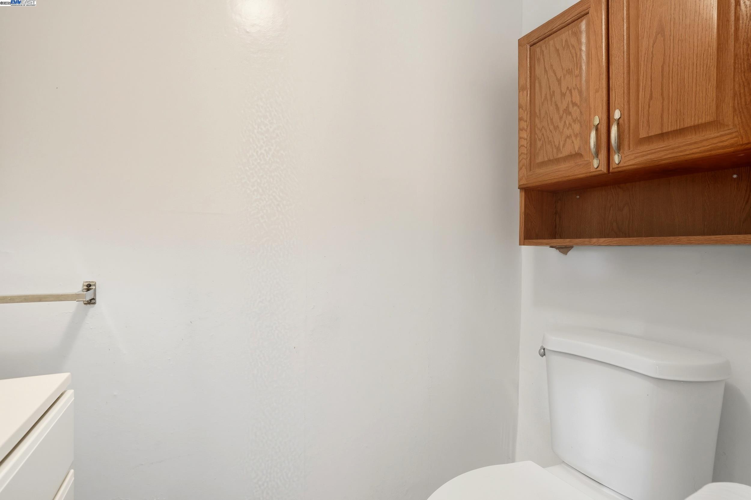 2067 Olivera Road, Unit B Concord, CA 94520 - Photo 8 of 23 a white toilet sitting next to a wooden cabinet