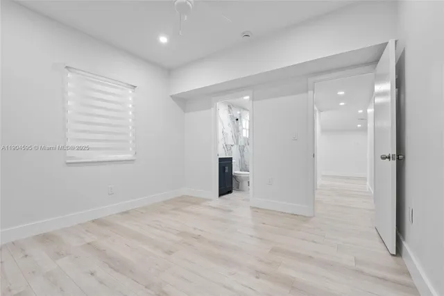 wooden floor in an empty room with a bathroom